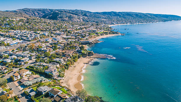 Aerial view of the Orange County coastline with homes and clear blue water.