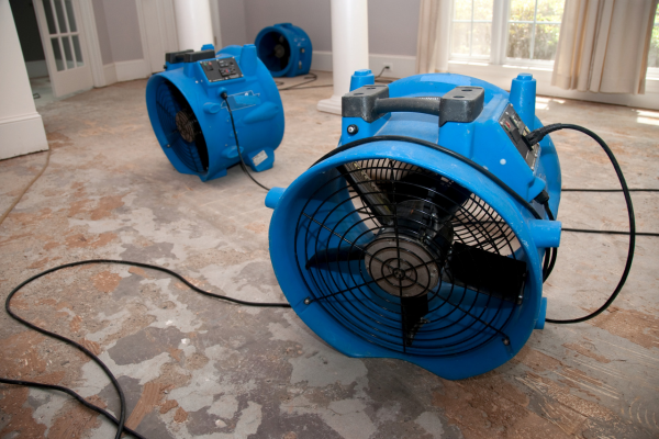 Restoration equipment, including fans and dehumidifiers, being used to address water damage